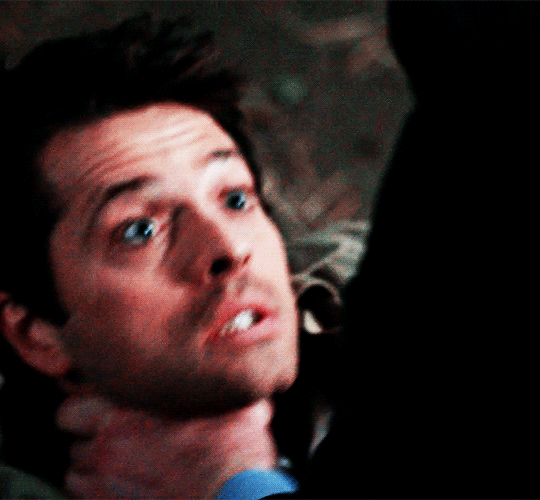 castiel from cw's supernatural, played by misha collins. he is being grabbed at the throat by someone off screen and he is looking up at them. he seems to struggle, then get his bearings as he adjusts to breathe better.